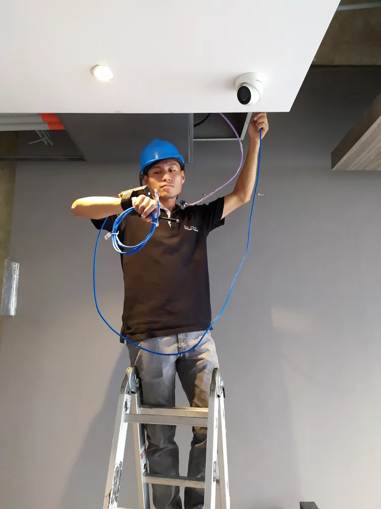 Técnico de Coltronix instalando una cámara de seguridad domo en Cali